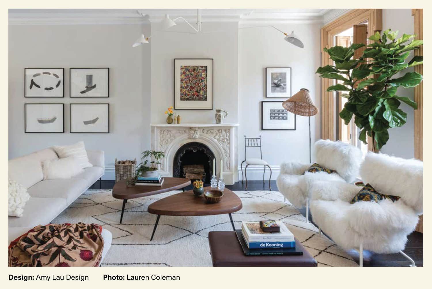 A living room created by Amy Lau Design features symmetrical wall art arrangements
