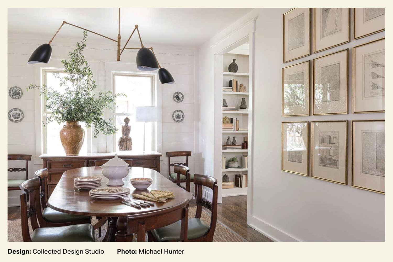 A dining room created by Collected Design Studio features a gallery-style wall hang